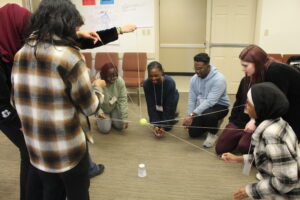 Students balancing a ball on strings together in a group activity